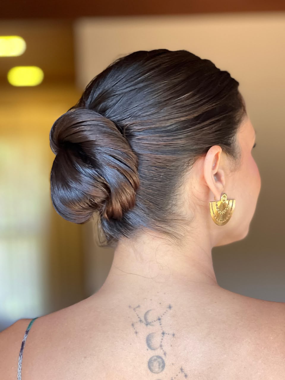 Acabamento de penteado de noiva visto de costas em hotel